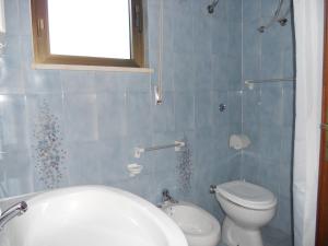 a blue tiled bathroom with a toilet and a sink at Villetta Patitari in Gallipoli