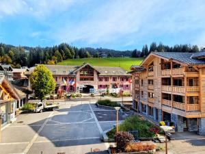 eine Luftaufnahme eines Resorts mit einem Parkplatz in der Unterkunft Appartement spacieux au cœur des Gets avec balcon, parking, et Wifi - FR-1-598-82 in Les Gets