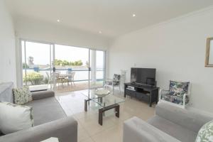 een woonkamer met een bank en een tv bij The Nautical Nook in Gqeberha