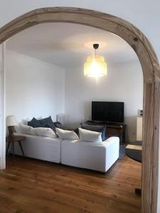 Una sala de estar con un sofá blanco y un televisor. en Bel appartement avec vue, en Hendaya