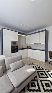 a living room with a couch and a kitchen at Blue Dream Apartment-City Center in Satu Mare