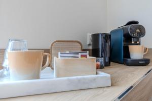 a tray with cups on a counter with a coffee maker at Hotel de Zon in Oosterwolde