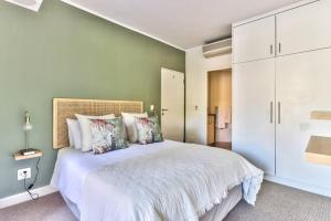 a bedroom with a large white bed with pillows at The Rockwell Apt in DeWaterkant next to Waterfront in Cape Town +14 photos