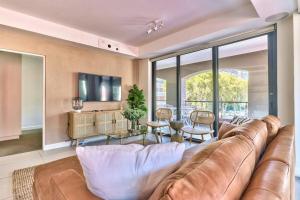 a living room with a leather couch and a tv at The Rockwell Apt in DeWaterkant next to Waterfront in Cape Town