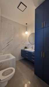 a bathroom with a toilet and a tub and a sink at Blue Dream Apartment-City Center in Satu Mare