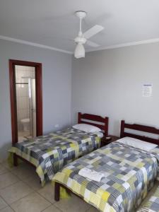 a bedroom with two beds and a ceiling fan at Hotel pousada vista alegre in Itapeva
