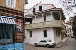 a white car parked in front of a building at Crystal Hotel Tbilisi in Tbilisi City