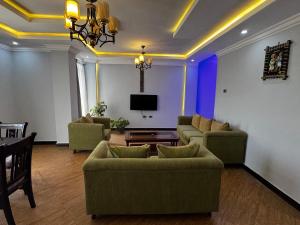 a living room with two couches and a tv at Family apartment Prime location and easy access 1 in Addis Ababa