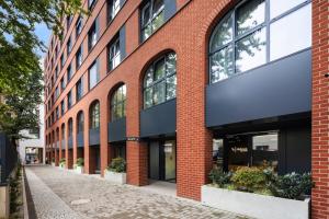 波兹南Aparthotel City Break Plac Wolności 6的街道上带大窗户的砖砌建筑 更多37张照片