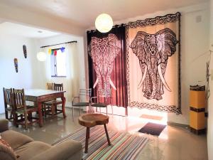 a living room with two paintings of elephants on the wall at Aconchego da Montanha in Garopaba