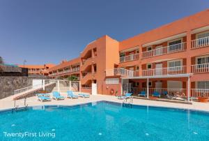 a large swimming pool in front of a hotel at Residence Playa Paraiso With Ocean View - Green Flat in Costa Calma +39 photos