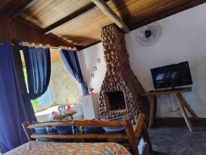 a living room with a fireplace and a tv at Pousada Bella Vista in Visconde De Maua