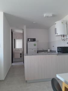 a kitchen with a counter and a kitchen with a sink at Departamento Buena Vista in Leones +3 photos