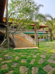 a staircase leading to a house with palm trees at Mansão Sunset Beach House in São Sebastião