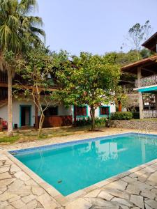 a swimming pool in front of a house at Mansão Sunset Beach House in São Sebastião