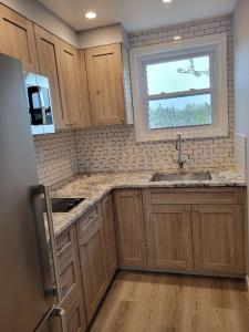 a kitchen with wooden cabinets and a sink and a window at Ocean Vista Resort in Amagansett