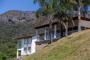 a house on top of a hill with palm trees at Fazenda Santa Ana do Garimpo in Barão de Cocais