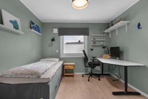 a bedroom with a bed and a desk and a computer at Villa with a view close to the city center in Tromsø