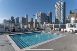 a swimming pool on top of a building with a city skyline at Iconic Heart of DTLA Loft with Rooftop Pool Jacuzzi Gym in Los Angeles