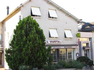 a building with a tree in front of it at L'Oustal in Naves