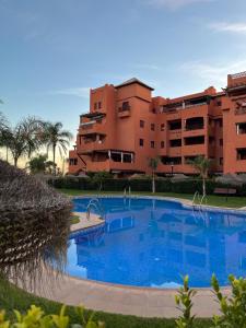 ein großer blauer Swimmingpool vor einem Gebäude in der Unterkunft Beach Apartment Tropical Golf in Motril