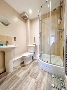 a bathroom with a toilet and a sink and a shower at 6 SERVICED APARTMENTS at ST JOSEPHS COURT, CLEETHORPES by VISIT CLEETHORPES in Cleethorpes +88 photos