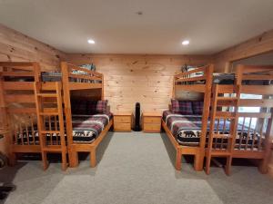 a room with four bunk beds in a cabin at Scoot Cabin - Dogs Welcome! in Carrabassett