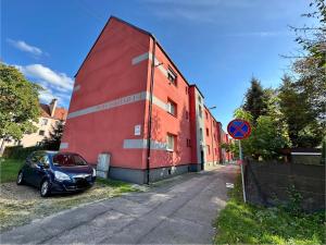 a red building with a car parked next to it at Apartament Kopalniok in Zabrze
