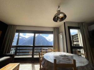 a dining room with a table and a large window at Résidence Sequoias - Charmant appartement avec vue époustouflante MAE-5351 in Les Deux Alpes