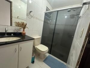 a bathroom with a shower and a toilet and a sink at Apartamento amplo e confortável 1 in Maringá +25 photos