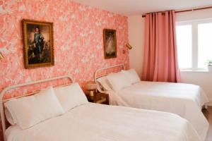 a bedroom with two beds and a painting on the wall at Boutique Accommodation in PEC - Suite 4 in Belleville