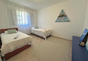a bedroom with two beds and a triangle on the wall at Apartamento amplo e confortável 1 in Maringá