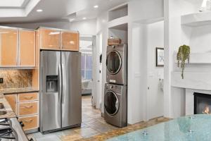 a kitchen with a refrigerator and a washer and dryer at Stunning Oceanfront Boardwalk Condo - Spa, Steps2Beach, Parking & Fast Wifi! in San Diego