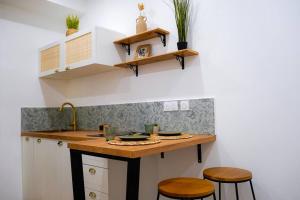 a kitchen with white cabinets and a counter with stools at Le Verger des Papes in Avignon