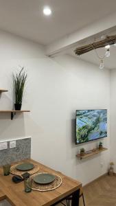 a room with a table and a tv on the wall at Le Verger des Papes in Avignon