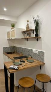a kitchen with a counter with two stools and a table at Le Verger des Papes in Avignon +6 photos