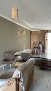 a living room with a couch and chairs and a table at Casa Cactos in Piranhas