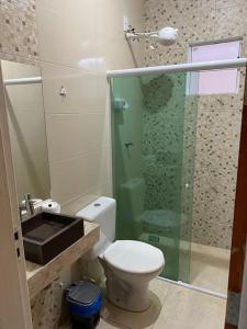 a bathroom with a toilet and a glass shower at Casa Cactos in Piranhas