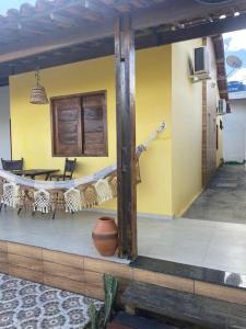 a porch of a house with a table and chairs at Casa Cactos in Piranhas