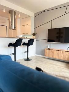 ein Wohnzimmer mit zwei Stühlen und einem Flachbildfernseher in der Unterkunft Pomorska Apartment in Breslau