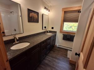 a bathroom with two sinks and a large mirror at Scoot Cabin - Dogs Welcome! in Carrabassett +19 photos