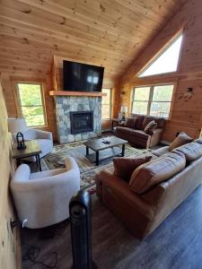 a living room with a couch and a fireplace at Scoot Cabin - Dogs Welcome! in Carrabassett