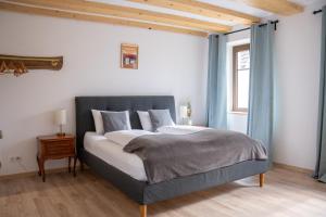 a bedroom with a large bed with blue curtains at Chambre Super Broussard in Eguisheim