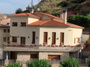 a white house with a balcony on a hill at La Villa de Herce in Herce