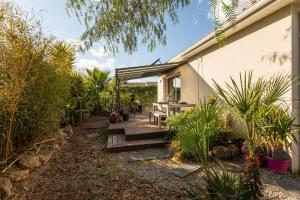 a house with a wooden porch with a table at "La scandinave" SPA et jardin luxuriant in Cers