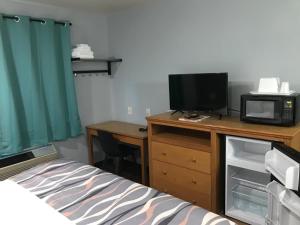 a bedroom with a bed and a desk with a tv at Valued Stay Sun Prairie in Sun Prairie