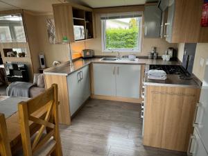 a small kitchen with a sink and a stove at Prestige Static Caravan on 5 Star Holiday Park in Cheswick