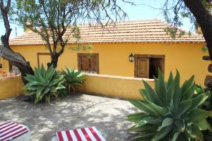 a yellow house with a fence and some plants at Casas Rurales Los Marantes in Puntagorda