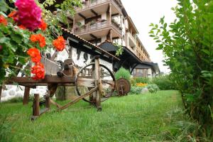 a flower garden with a woodenwheel in front of a building at Molerite Complex in Bansko
