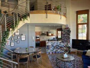 a living room with a spiral staircase and a kitchen at La Villa de Herce in Herce
